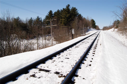 railway continues towards Acton. Depression to the left contains a pond
