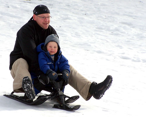 Brian and Tommy slide down a hill in the Beaches section of Toronto.