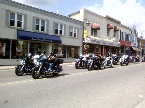 Motorcycle drivers pass through Acton, Ontario along Highway 7 (Mill St E)