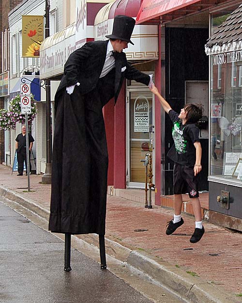 A Taste of Acton - stilt walker gets a high five